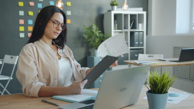 Virtual assistant reviewing documents and coordinating work on a laptop