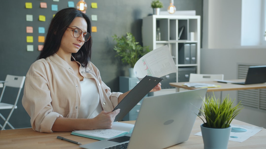 Virtual assistant reviewing documents and coordinating work on a laptop